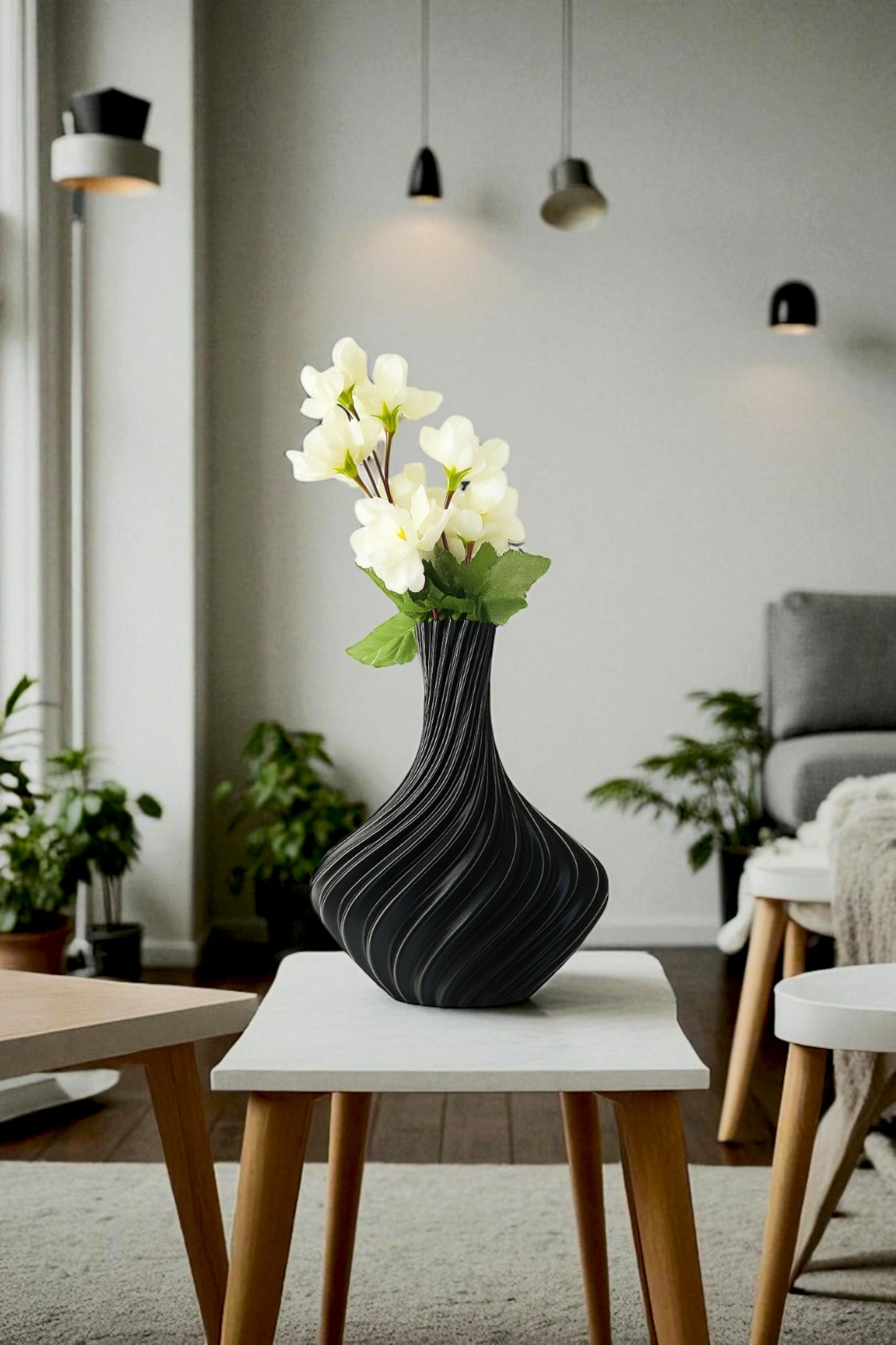 Black textured vase with white flowers on a white table in a living room setting